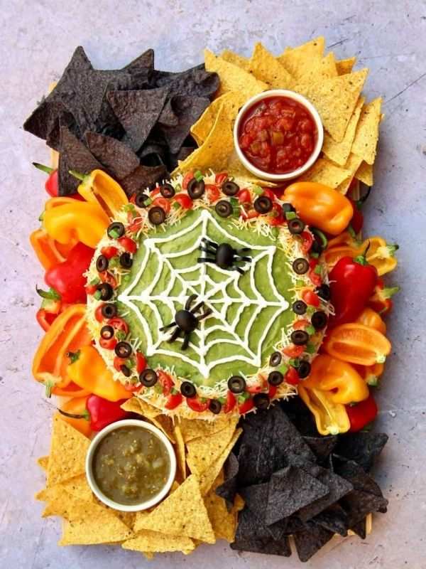 Creamy spinach-artichoke dip swirled with sour cream to form a spider web, topped with a black olive spider.
